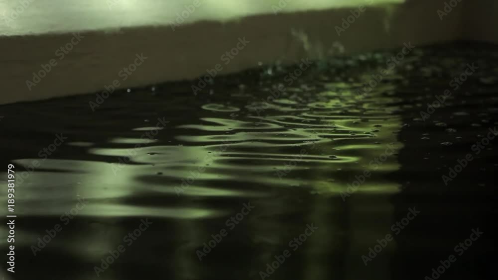 water falling in a dark spa pool with light reflections water falling in a dark spa pool with light reflections