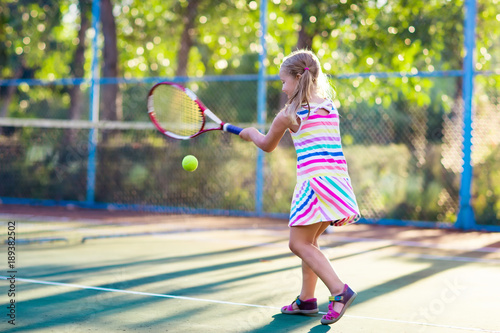 Child playing tennis on outdoor court