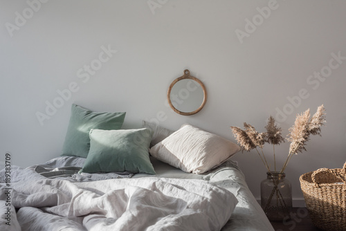 Schlafzimmer mit Bett und Spiegel an der Wand, Korb und Dekoration photo