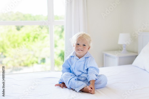 Kids in bed. Children in pajamas. Family bedroom. © famveldman