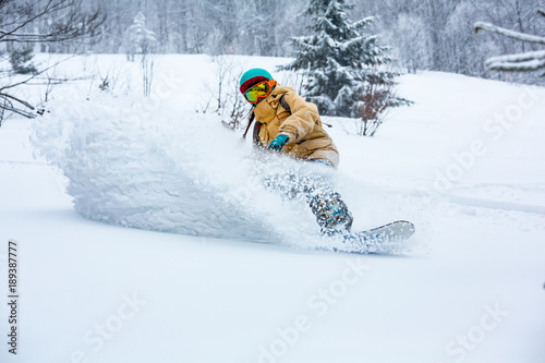 Obraz na płótnie A snowboarder girl is riding down the hill