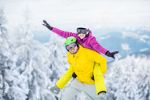 Young couple in snowboarding clothes having fun during the winter vacation on the snowy mountains
