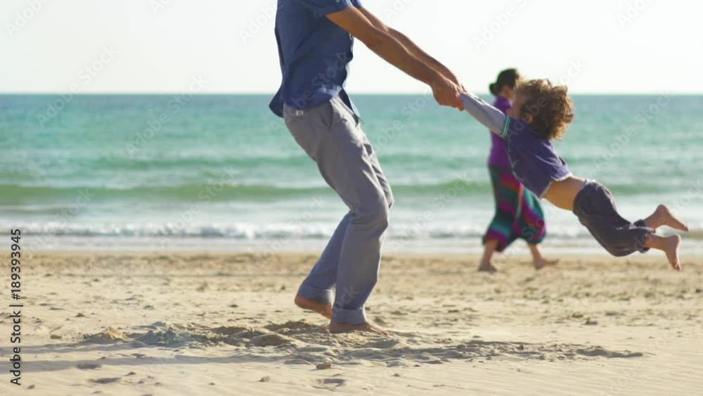 Young family in the beach playing and enjoying together, smiling, in a loving way Young family in the beach playing and enjoying together, smiling, in a loving way