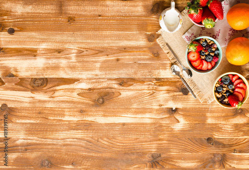 Cereal. Breakfast with muesli, and fresh fruits in bowls on a rustic wooden background,