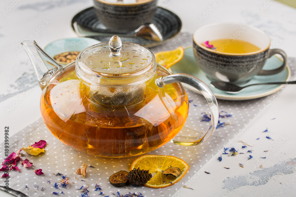 Serving table for breakfast, orange tea in teapot and cup on a white table Serving table for breakfast, orange tea in teapot and cup on a white table