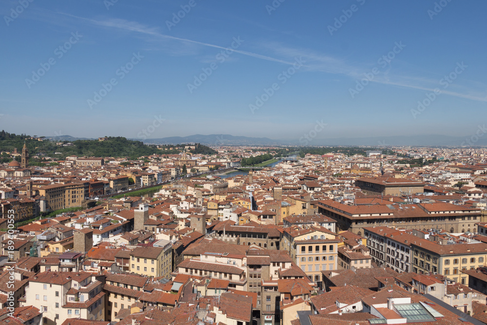 Florentine cityscape with red roofs and Arno river in a sunny day, Tuscany, Italy.