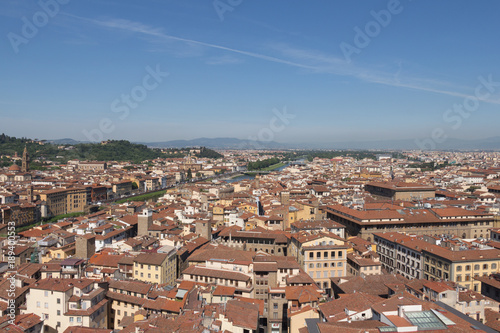 Florentine cityscape with red roofs and Arno river in a sunny day, Tuscany, Italy.