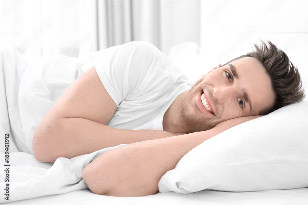 Young man lying on white pillow at home Young man lying on white pillow at home