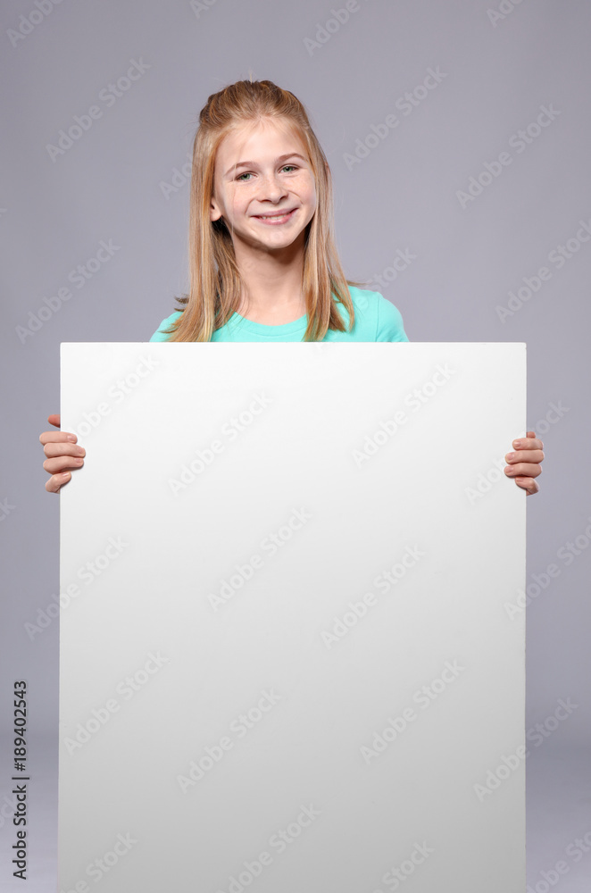 Cute girl with blank advertising board on grey background Cute girl with blank advertising board on grey background