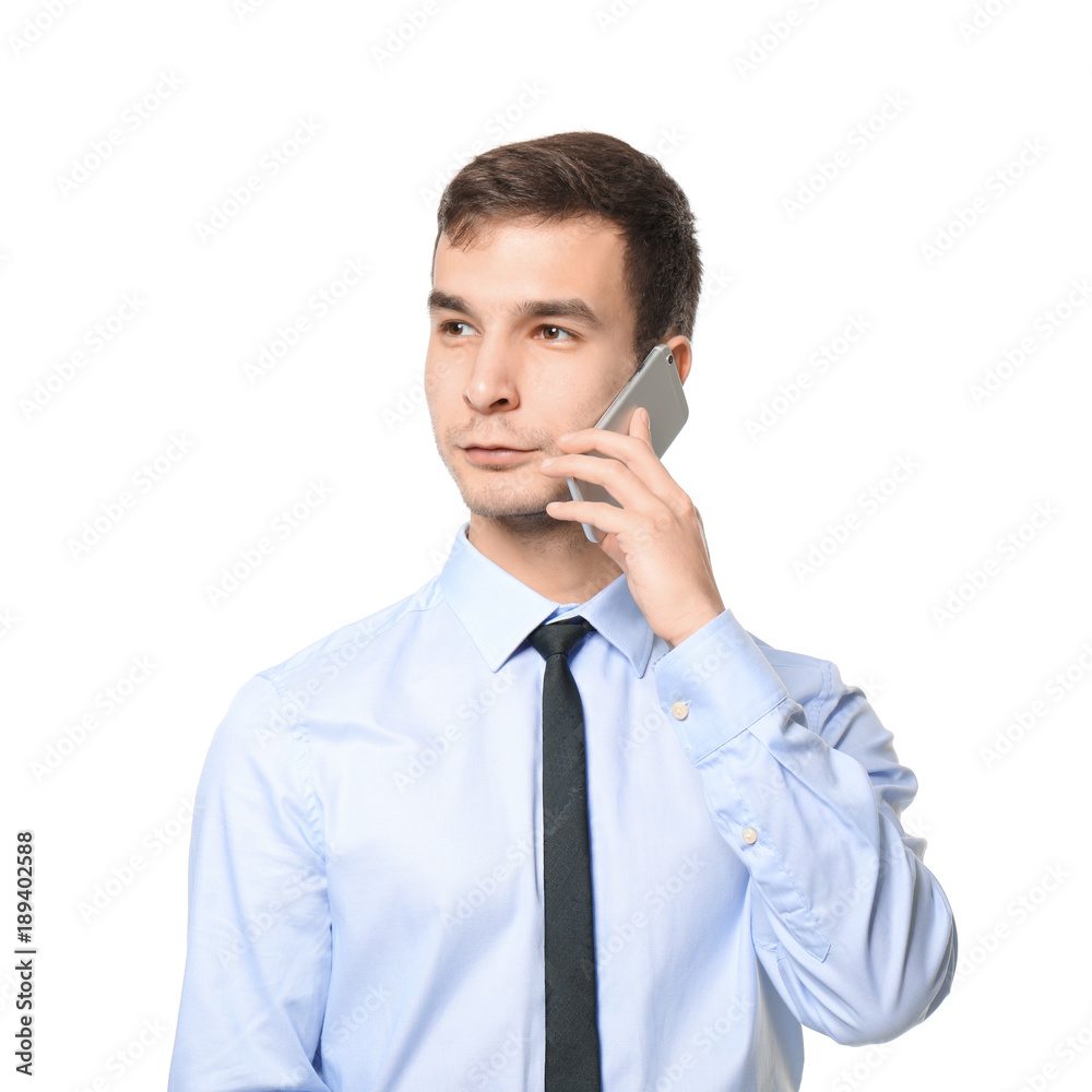 Handsome car salesman talking on mobile phone against white background Handsome car salesman talking on mobile phone against white background