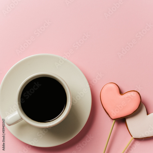 Valentine day background with gingerbread hearts and a cup of coffee, top view with space for your text