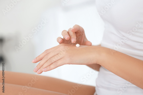 Young woman applying hand cream, closeup