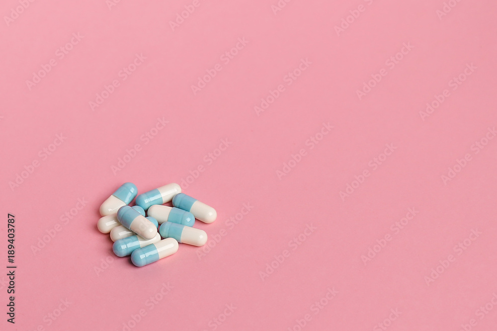 blue pills capsules on pink background closeup. place for text. blue pills capsules on pink background closeup. place for text.