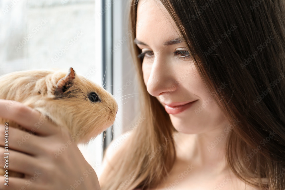 Beautiful young woman with funny guinea pig, closeup Beautiful young woman with funny guinea pig, closeup
