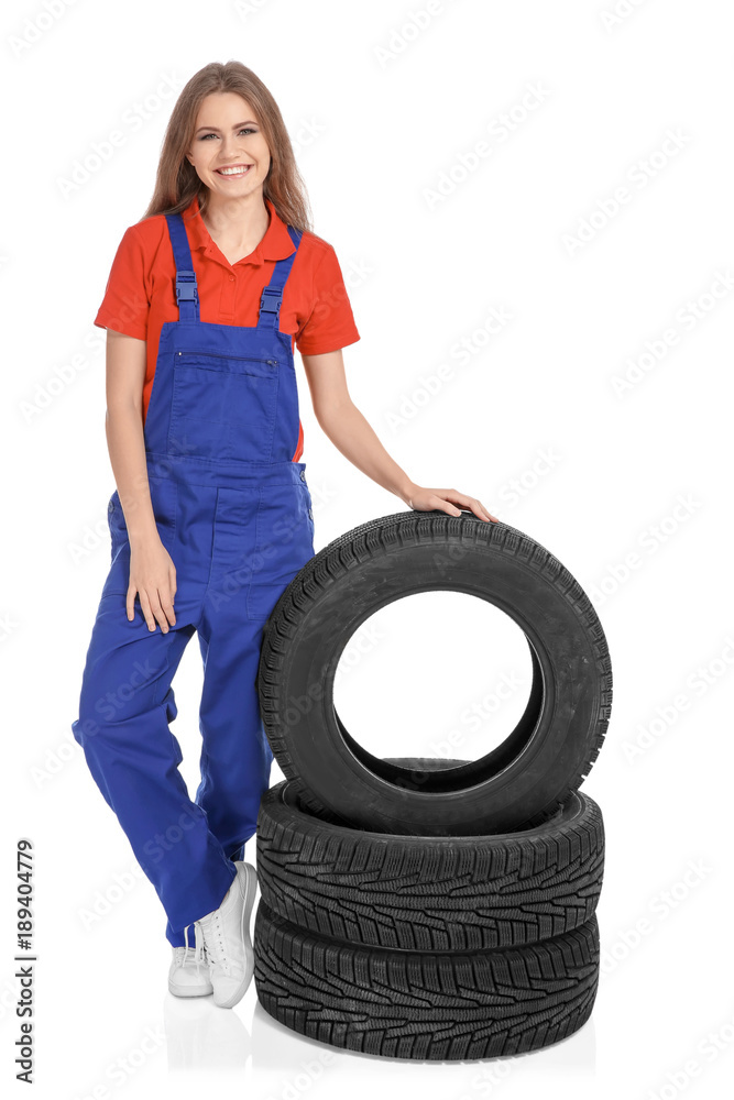 Female mechanic in uniform with car tires on white background Female mechanic in uniform with car tires on white background