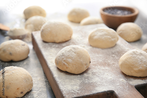 Unbaked buns of dough on table