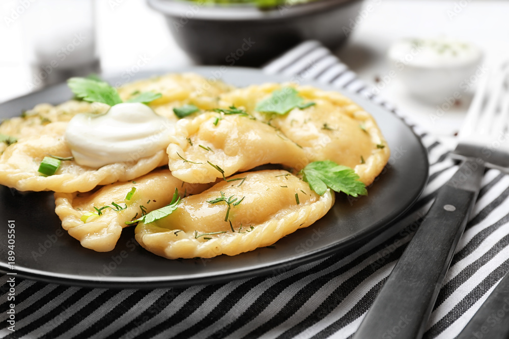 Plate with tasty dumplings on table, closeup Plate with tasty dumplings on table, closeup