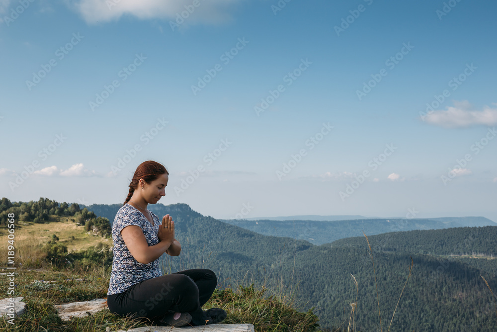 Young girl or woman relax or meditate in mountains