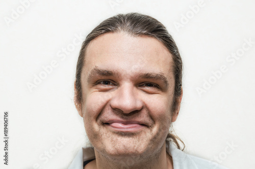 Funny smiling man looking at camera on white background