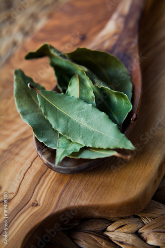 Fototapeta Naklejka Na Ścianę i Meble -  Dry Bay Leaves - aromatic Indian spices on wooden spoon, macro.