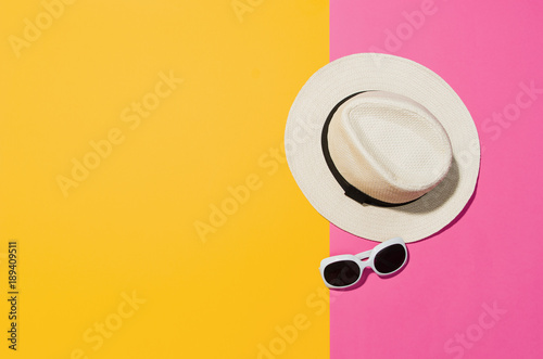 Top view of sandy beach with towel frame and summer accessories. Punchy pastels colors graphical background with copy space. Right border made of towel