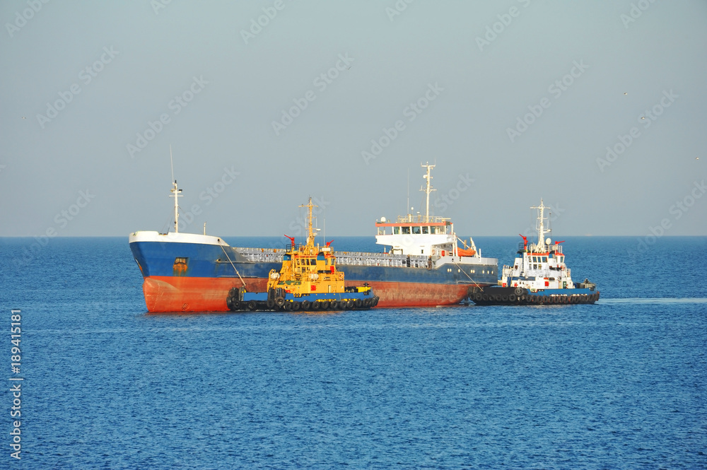 Tugboat assisting bulk cargo ship