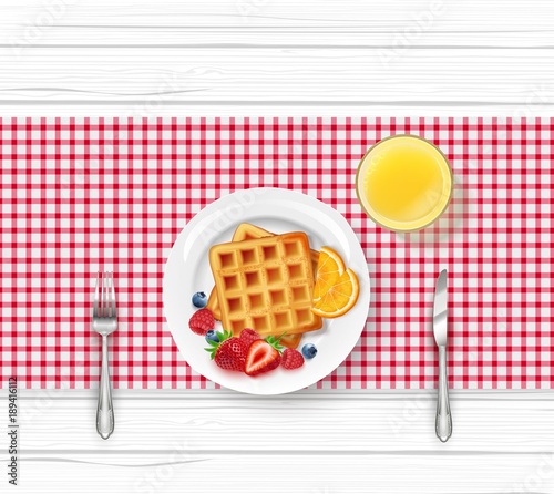 Breakfast menu with waffles and orange juice on wooden table