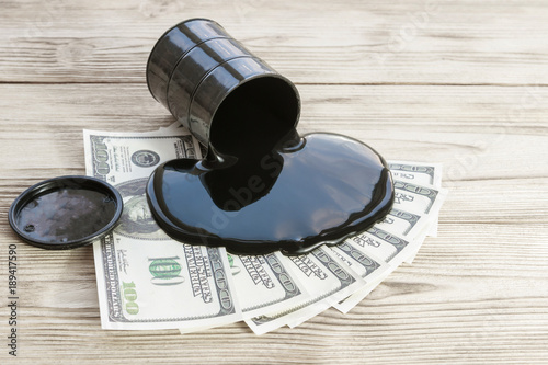 Spilled oil from a barrel on the bills dollar money, black gold. Sales purchase sale. business income, the fall or the price increase.