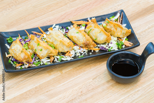 Gyoza , Guyza in black plate with soy sauce dumplings on wooden table, popular Japanese Food on Wooden Background photo