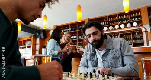 Friends playing chess in bar 