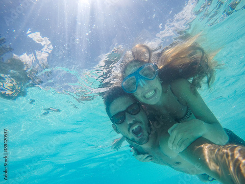 Couple in love taking a selfie doing snorkeling in the ocean photo