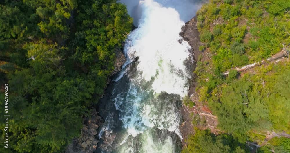 Beautiful water fall through forest cliff on a sunny day Beautiful water fall through forest cliff on a sunny day