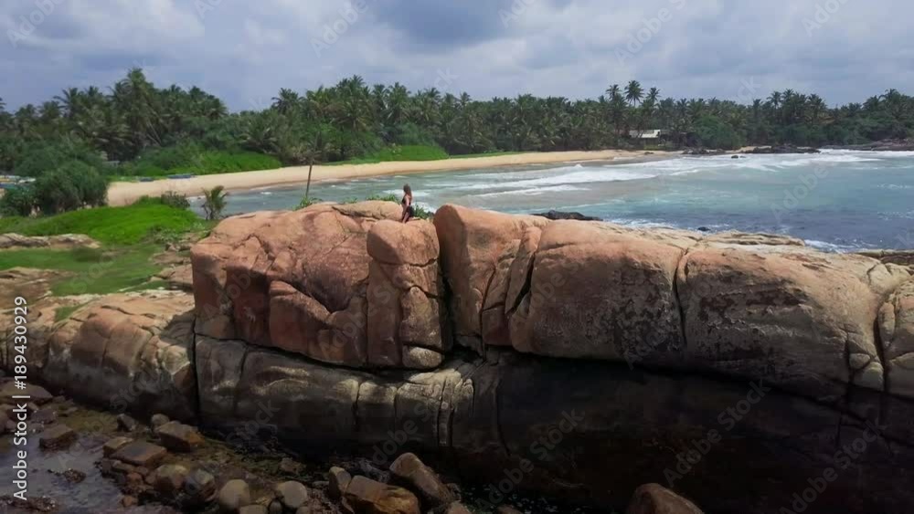Young girl do half spinal twist yoga pose on stone sunrise drone footage Young girl do half spinal twist yoga pose on stone sunrise drone footage