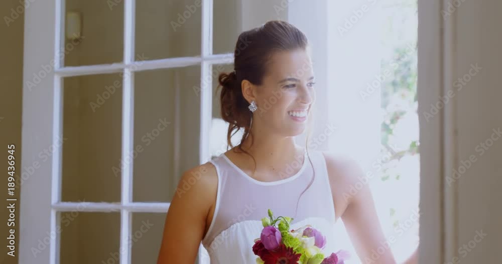Bride standing near the window with a bouquet Bride standing near the window with a bouquet
