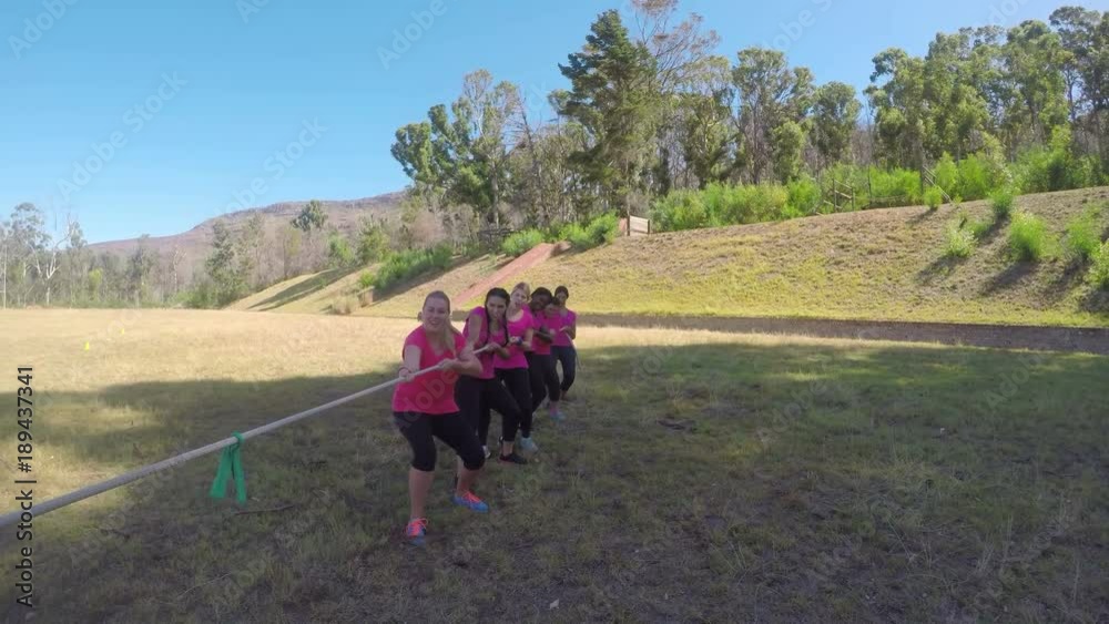 Kids in uniform playing tug of war during obstacle course Kids in uniform playing tug of war during obstacle course