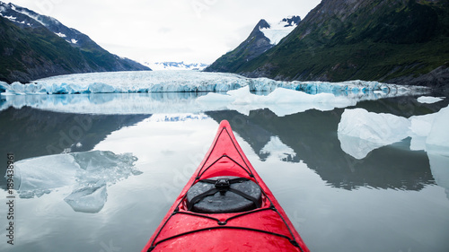Photography Red kayak floating among icebergs looking toward a glacier in Alaska