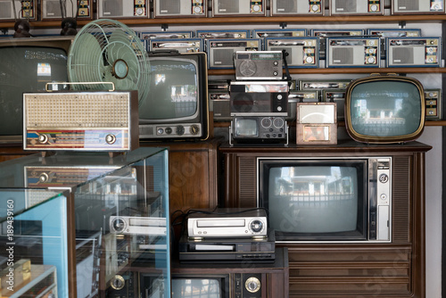 Old vintage different radios, television and electronic in antique store shelves.