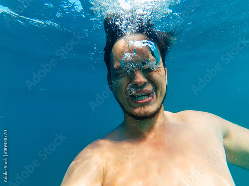 man underwater drowning with an expression of fear