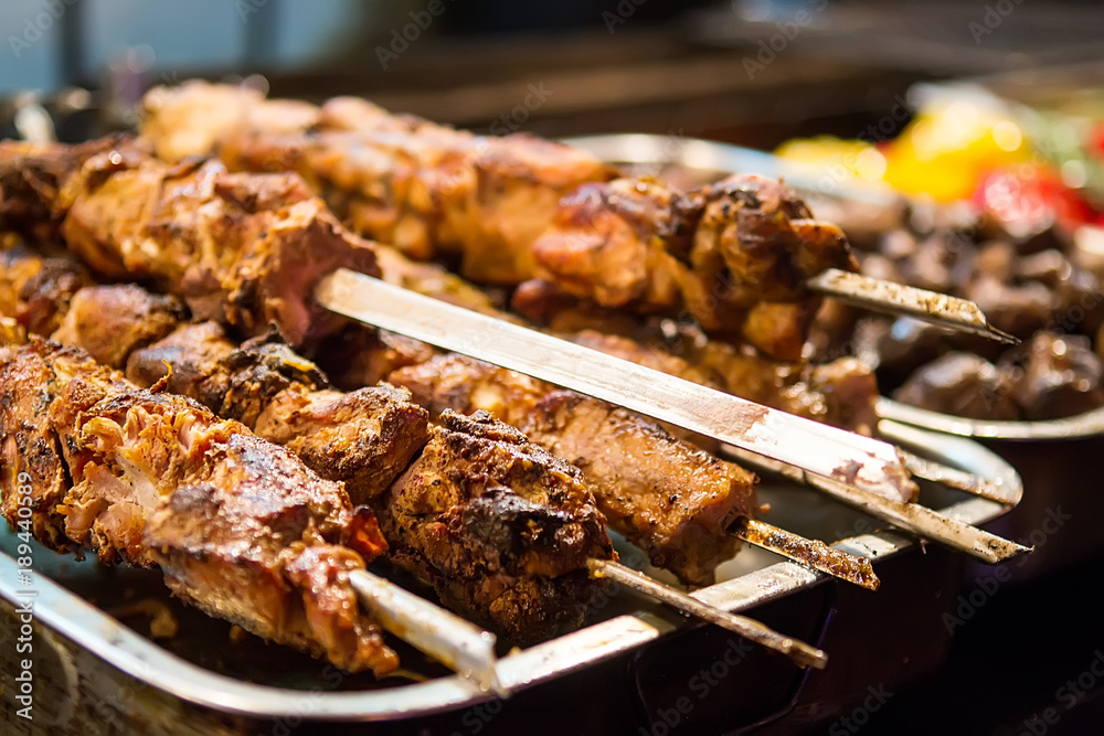 Meat skewers grilled on food market. Selective focus