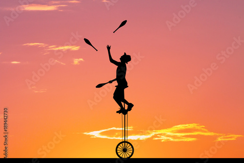 juggler with ninepins at sunset