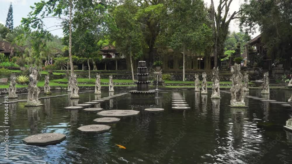 Hindu Balinese Water Palace Tirta Gangga with statues of the gods, fountains on Bali island, Indonesia. Tirta Gangga the former royal water palace is a maze of pools and fountains surrounded by a lush