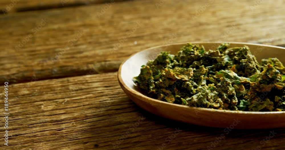 Dried herbs in plate on wooden surface Dried herbs in plate on wooden surface