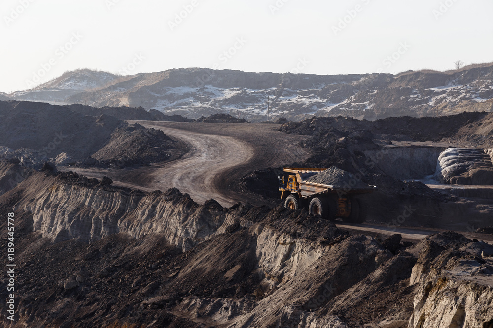Coal section, Primorsky Krai, Russia - March 2017: chalk pit. Excavator pours soil into the truck Coal section, Primorsky Krai, Russia - March 2017: chalk pit. Excavator pours soil into the truck
