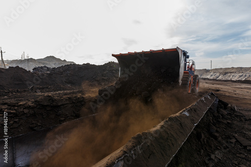 Coal section, Primorsky Krai, Russia - March 2017: chalk pit. Excavator pours soil into the truck photo