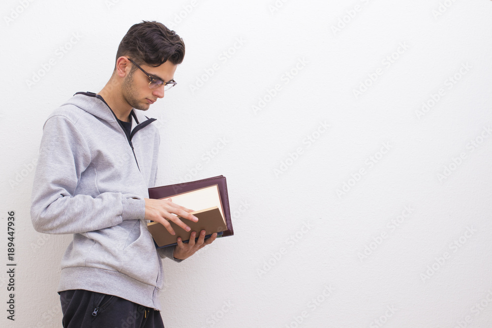 young student with books on the white wall