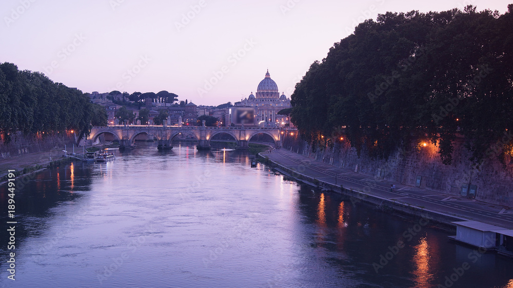 View of the St. Peter's Basilica and Ponte Sant'Angelo at sunset in Rome, Italy.