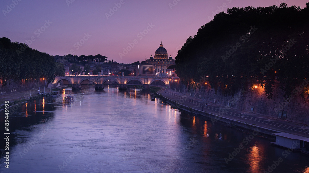 View of the St. Peter's Basilica and Ponte Sant'Angelo at sunset in Rome, Italy.