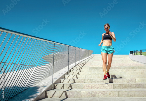 Blonde woman running training near the modern architecture build
