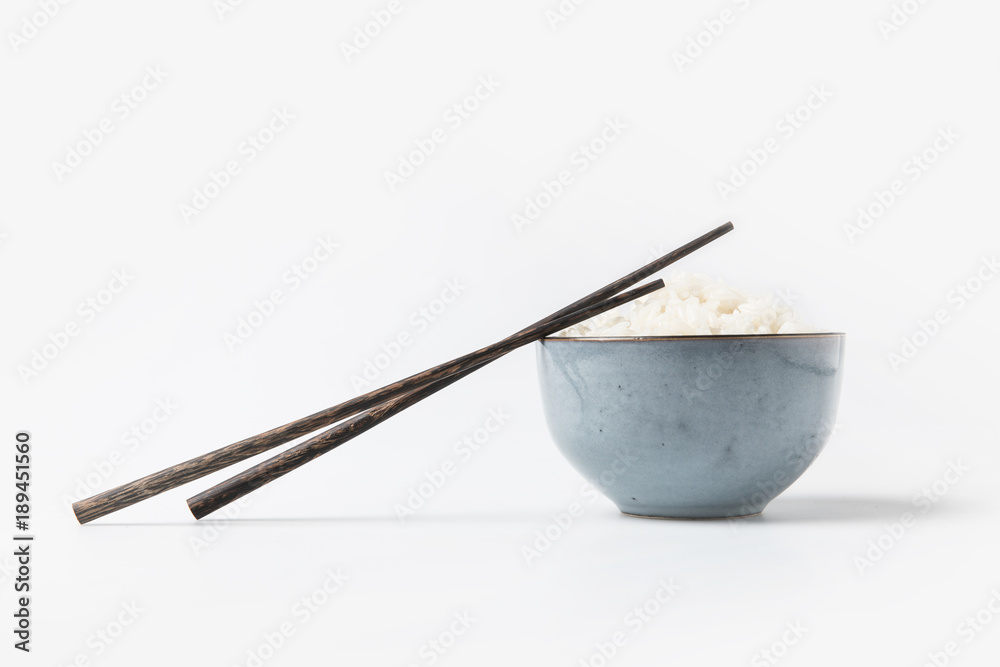 bowl of tasty rice with chopsticks on white tabletop