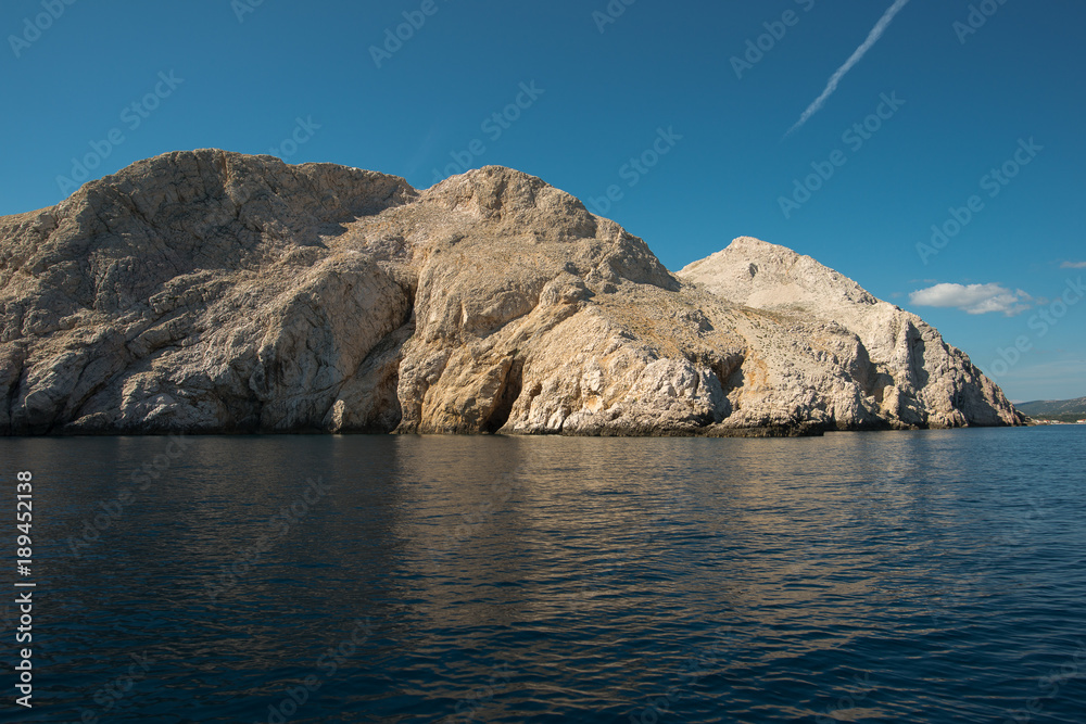 Beautiful travel image. Sunset over sea and small island.